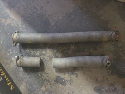 Old galvanized broken garage door portions springs.
