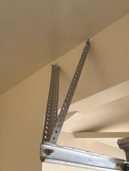 Track hanger should be rebuilt as the attachment style is not solid and looks bad. 

Should be attached to the ceiling not the beam.