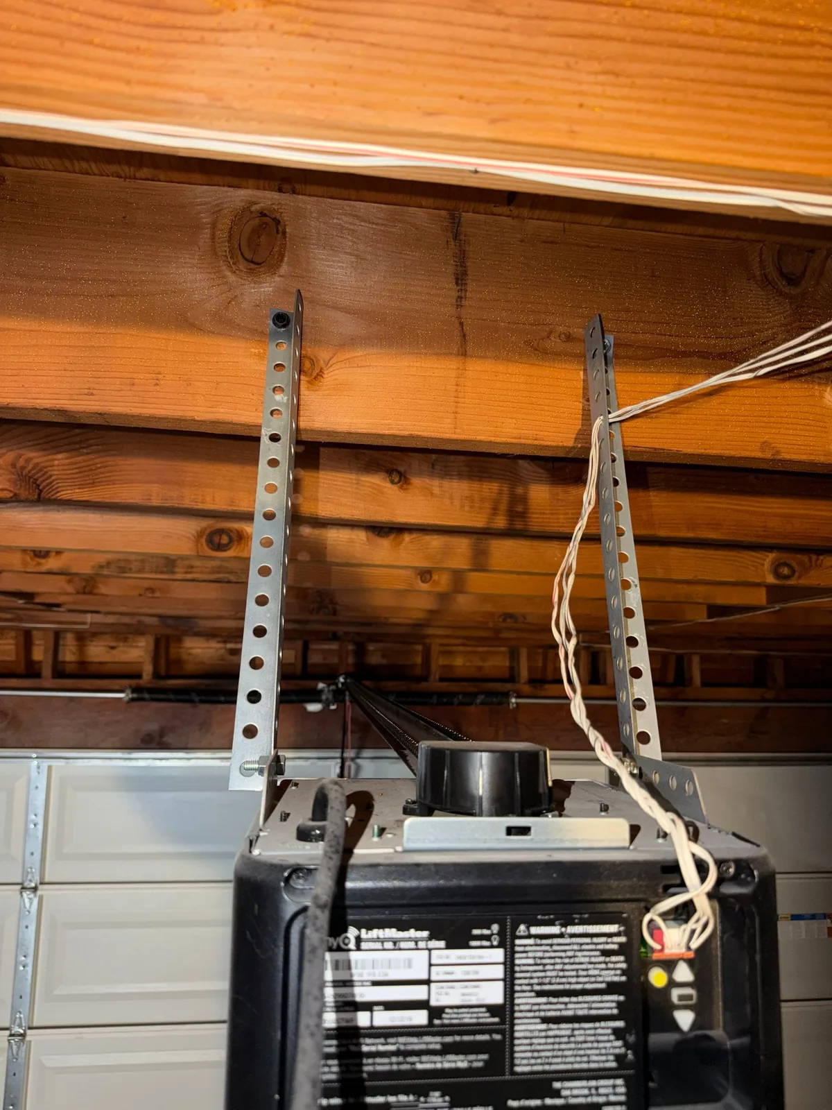 Old garage door opener mount with untidy overhead wiring.