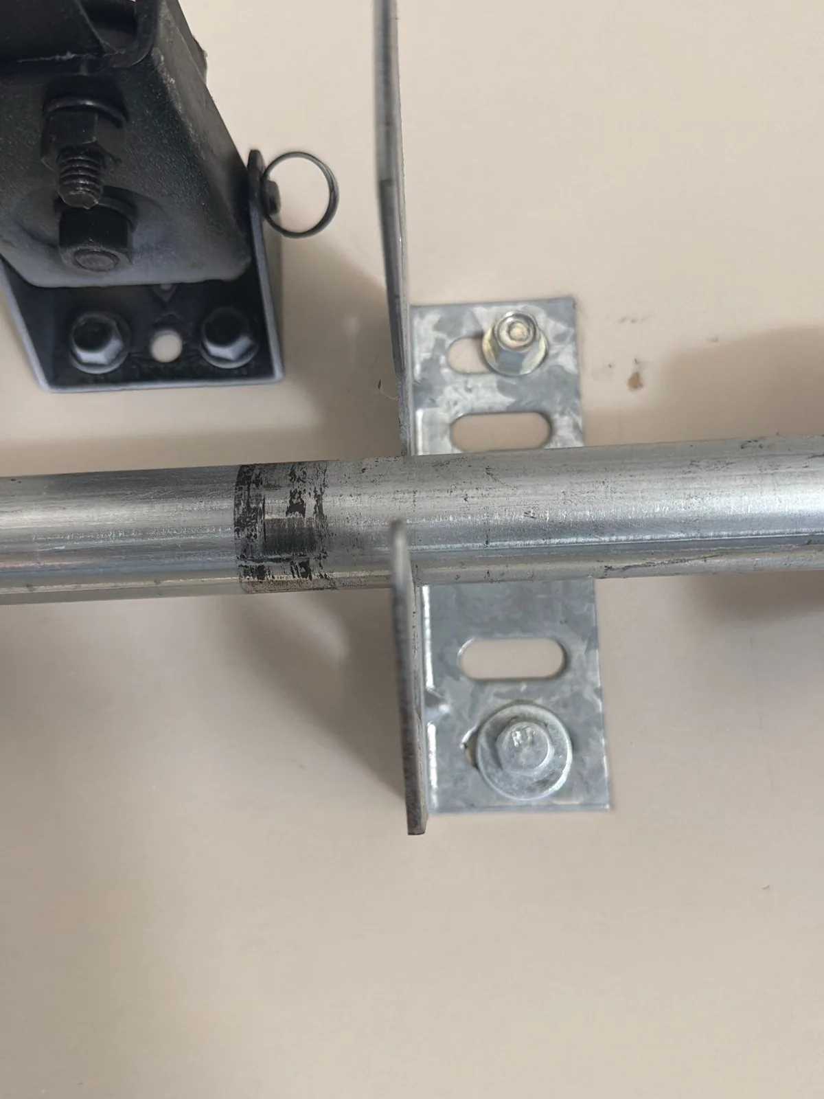 Existing garage door center support plate secured with two bolts.