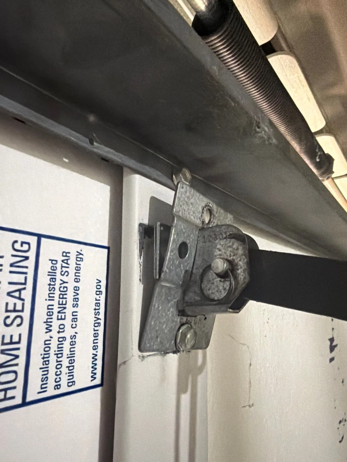 Damaged garage door opener support bracket near the ceiling.