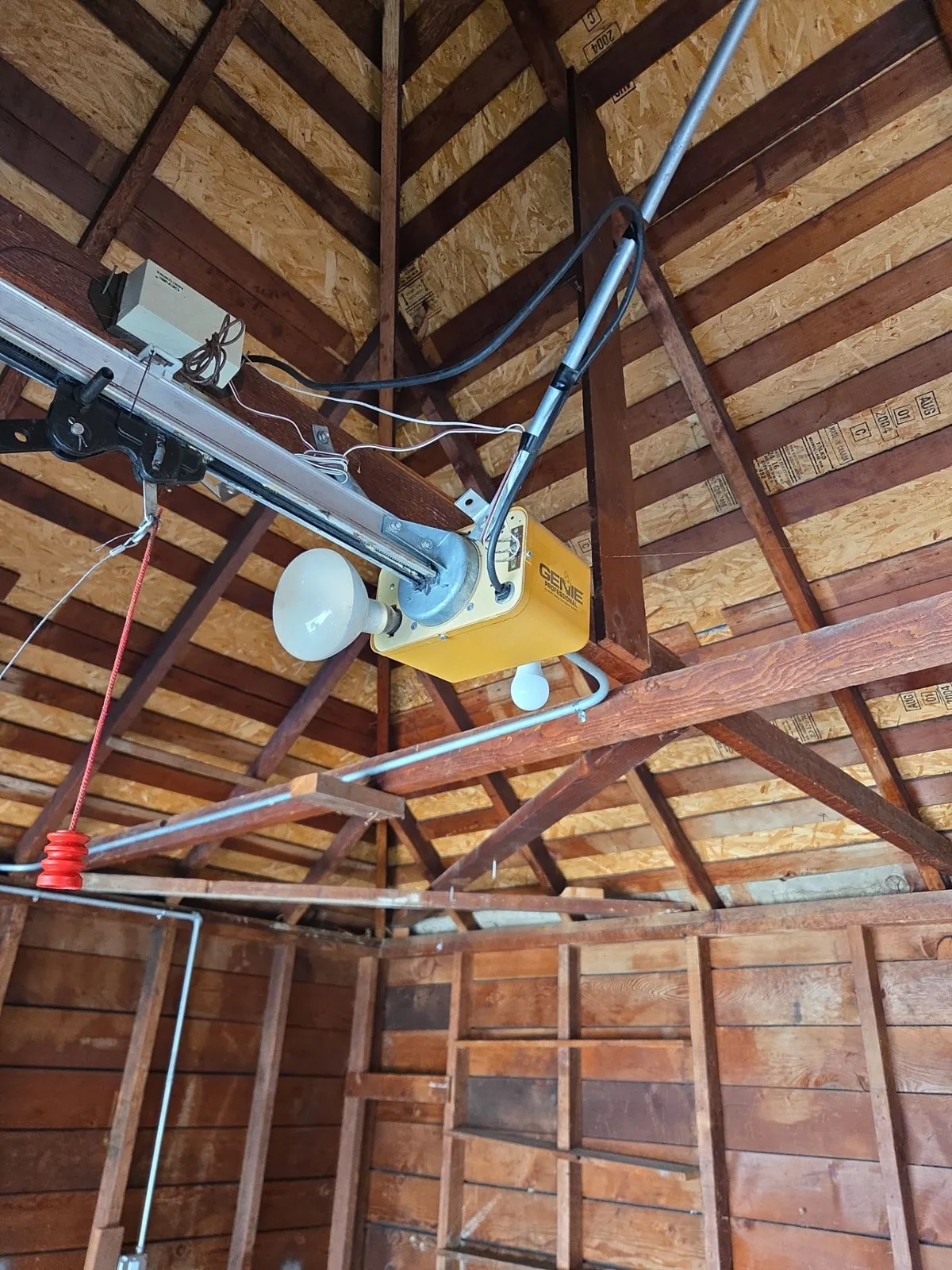 Older Genie garage door opener mounted near the ceiling.