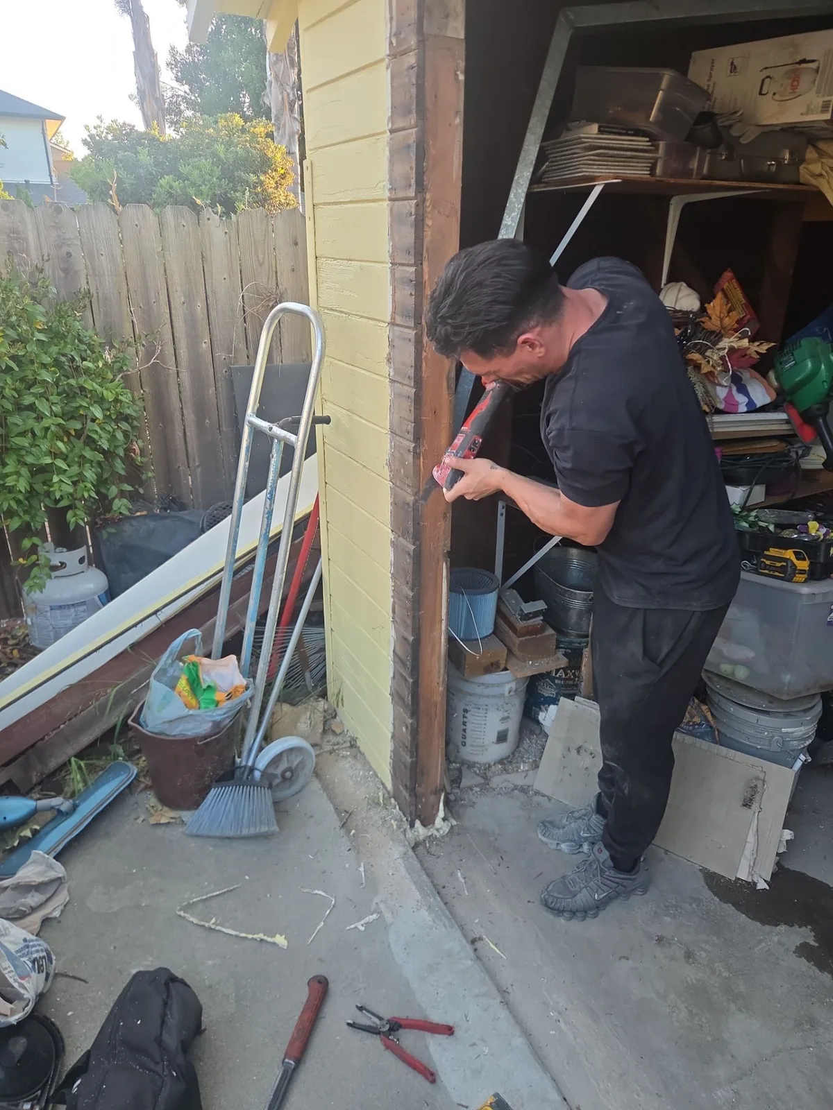 Deteriorated exterior trim being removed beside a garage door.
