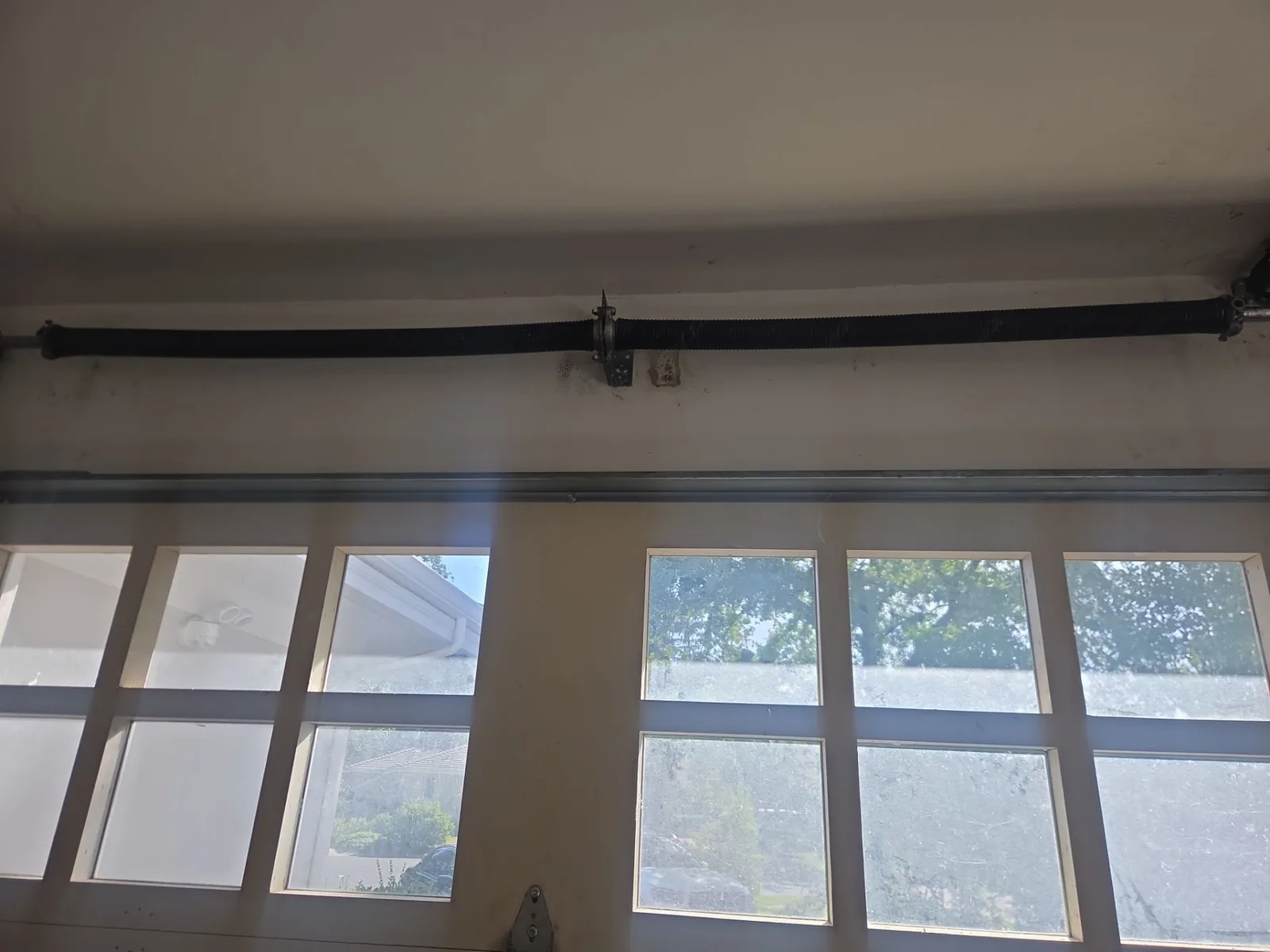 Updated torsion spring system with a new left-side spring above the garage door.