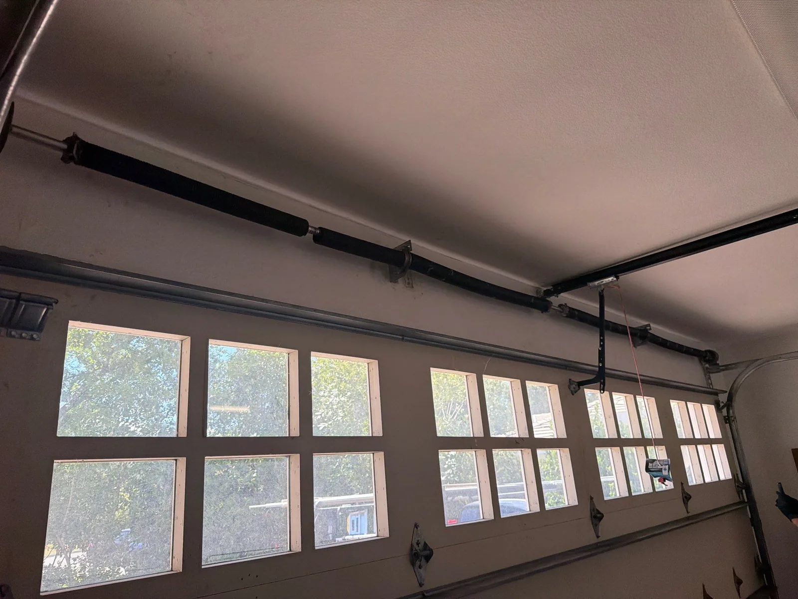 Four-spring torsion system above a garage door before spring repair.