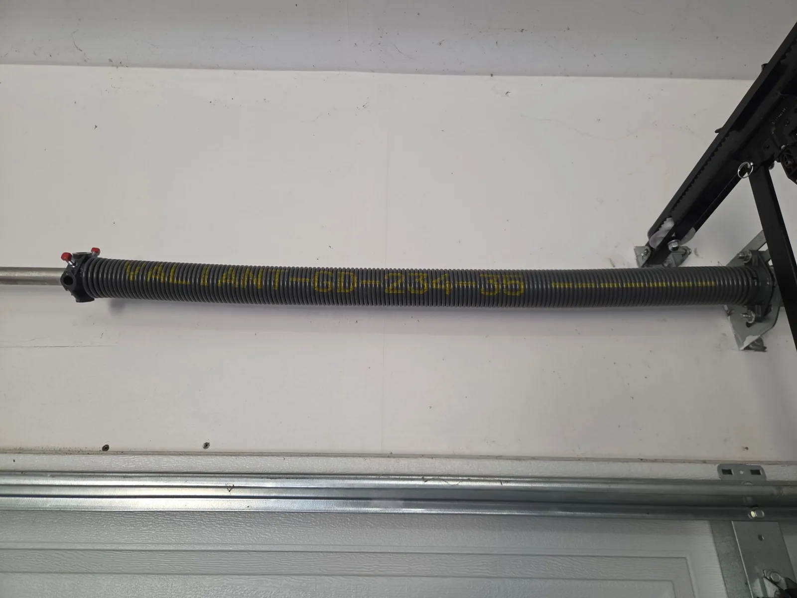 New torsion spring hardware installed above the garage door.