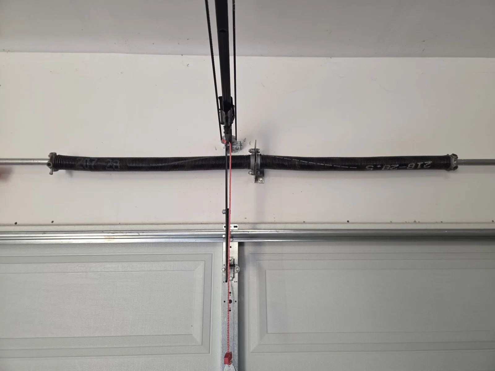 Broken garage door torsion spring above the door.