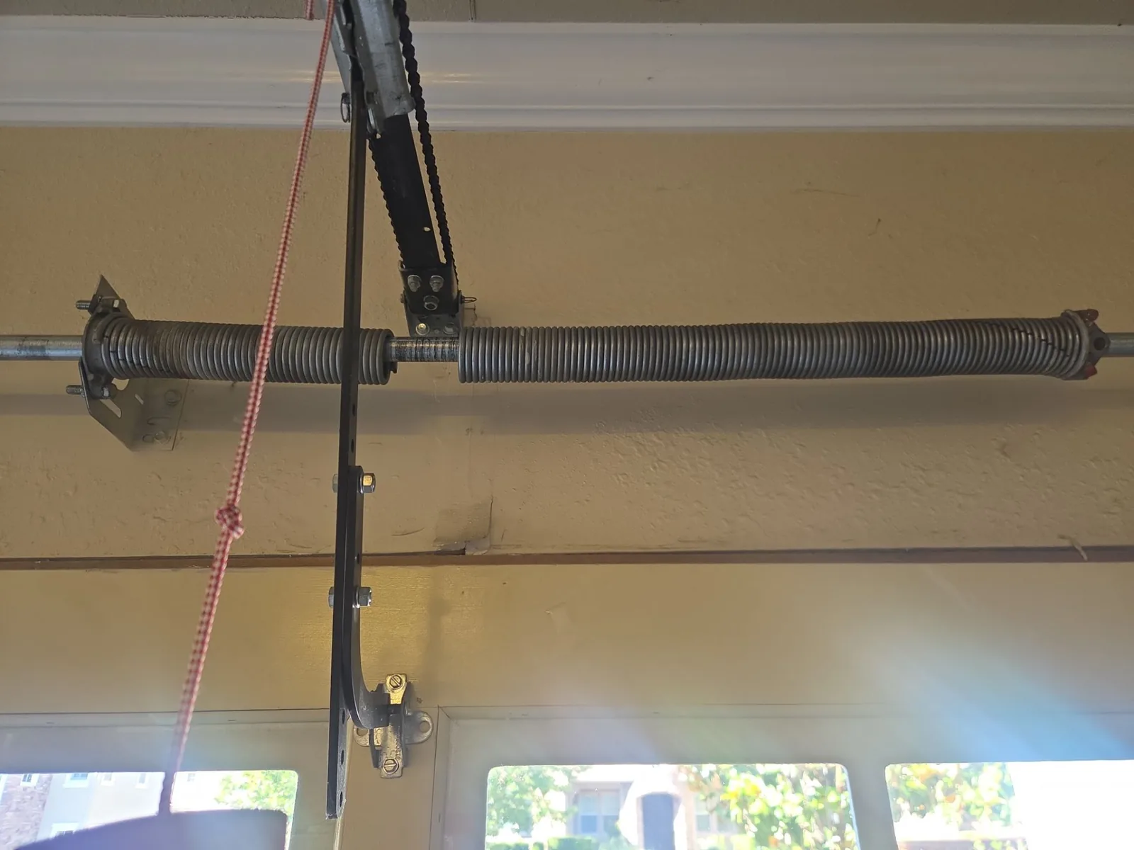 Broken torsion spring assembly above the garage door opening.