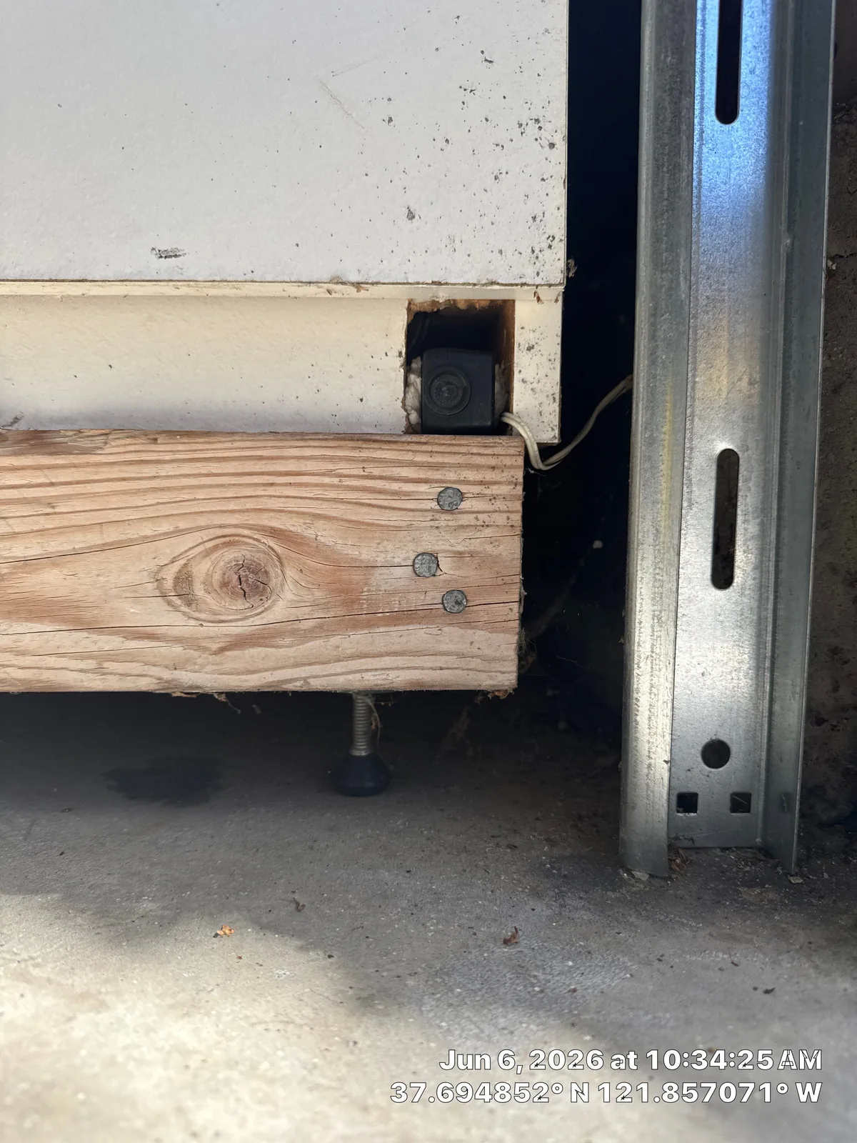 Existing garage door safety sensor location near the lower track.
