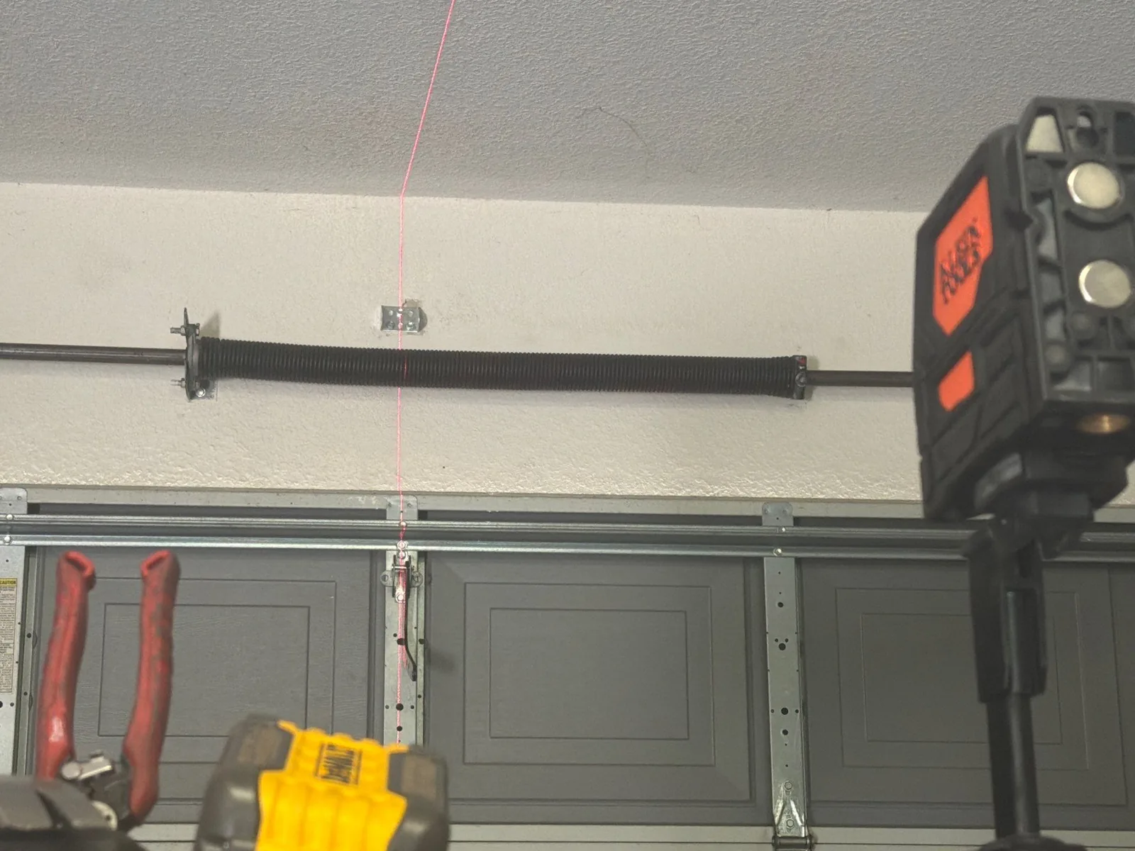 New garage door opener mounting hardware and aligned J-arm above the door.