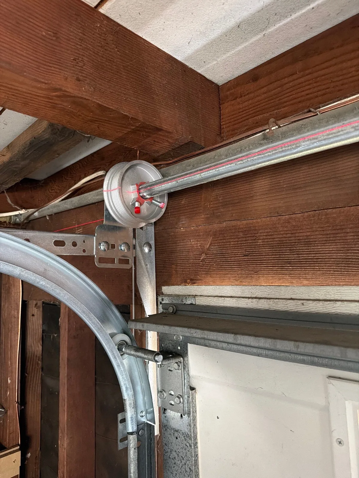 Completed torsion spring and cable hardware installed above the garage door.