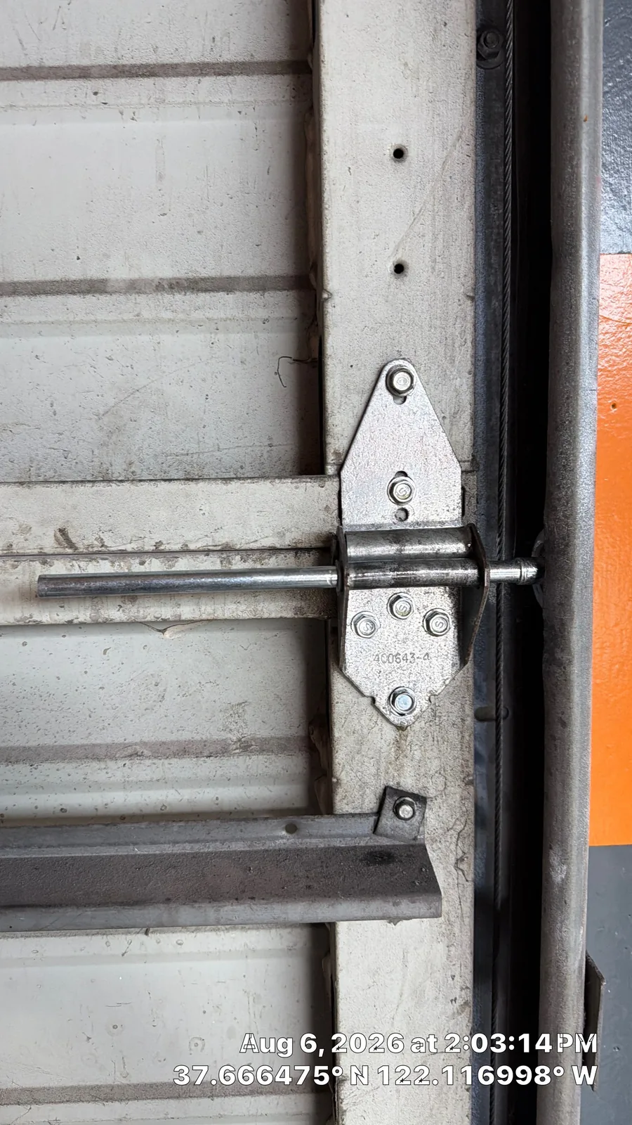 New garage door roller and secured hinge hardware beside the vertical track.