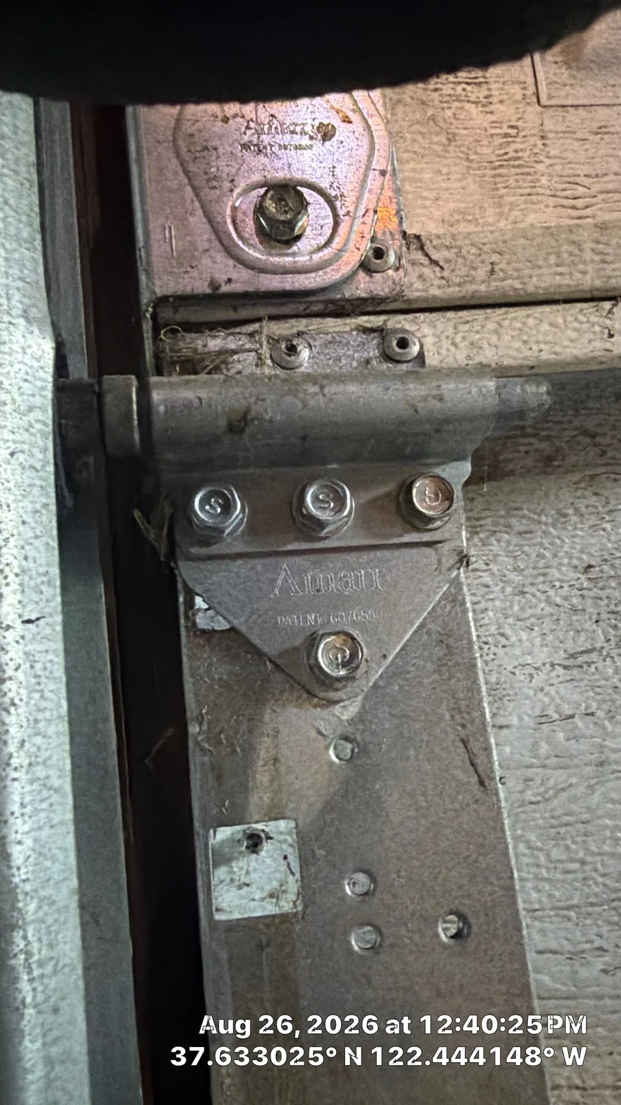 Repaired hinge and roller mount secured to the same garage door section.