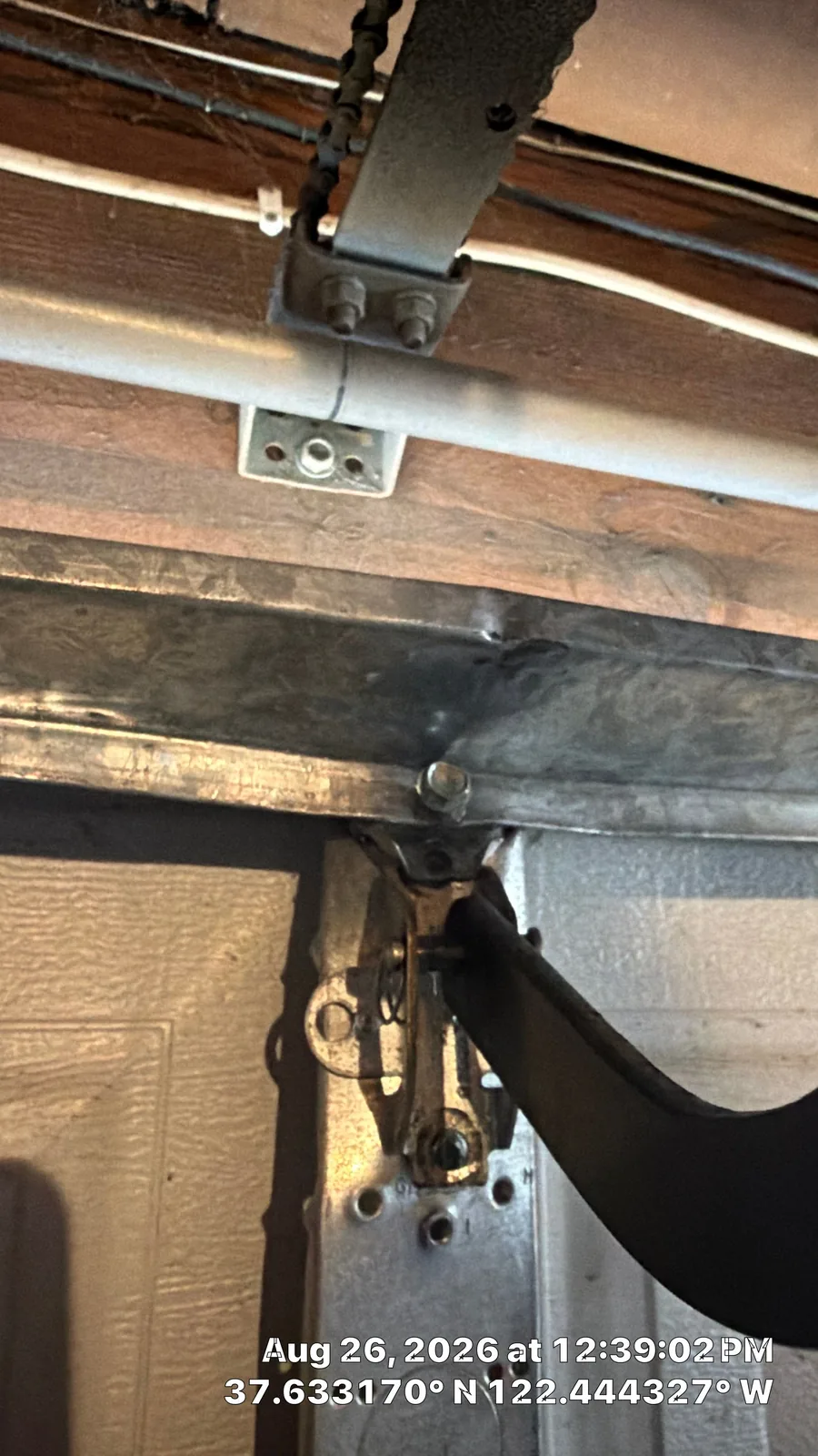Detached operator-bracket mounting area on a San Bruno garage door center stile.