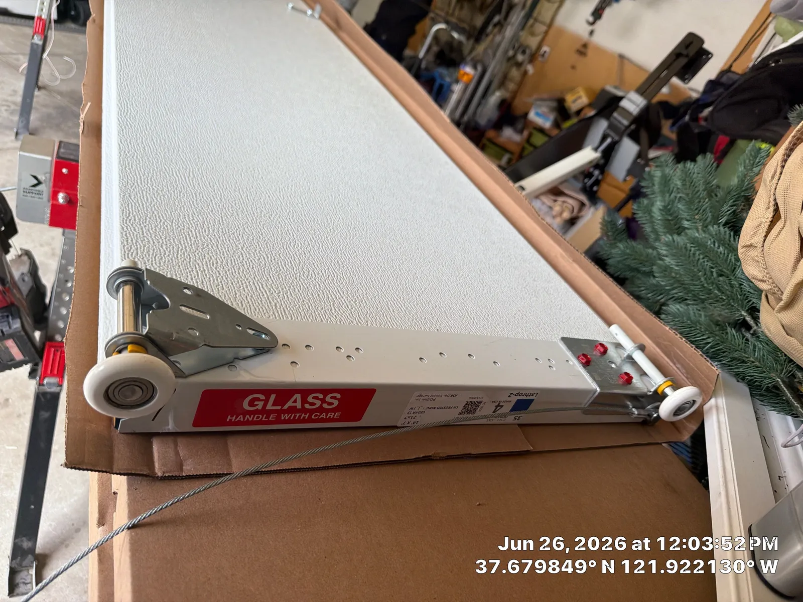 Pleasanton garage door panel and roller assembly staged for installation