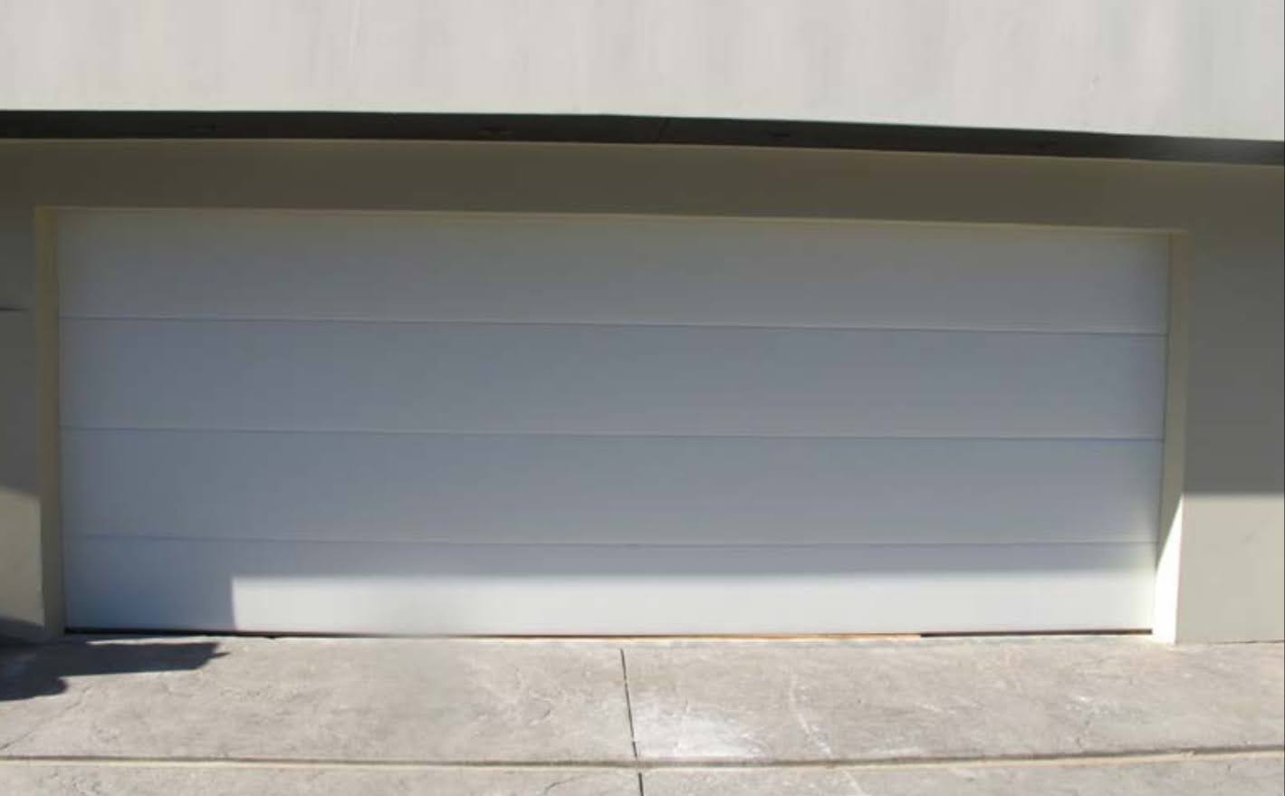 clean white flush panel garage door fabricated by Valiant Garage Door