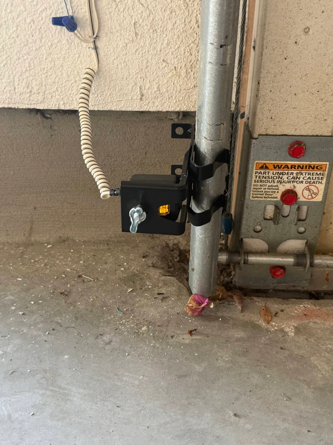 Garage door safety photo-eye sensor mounted on the track