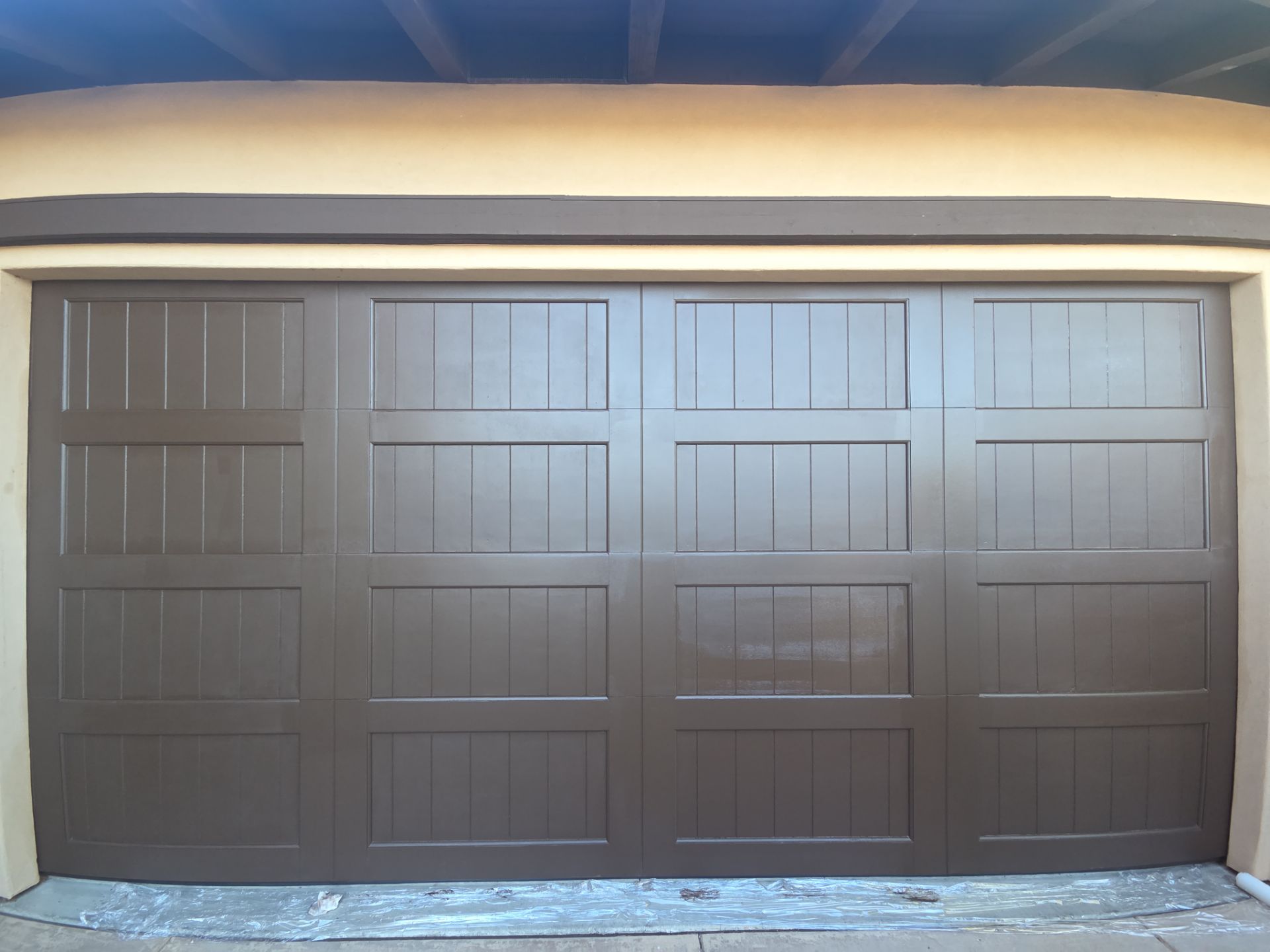 Freshly refinished brown wood-look sectional garage door completed by Valiant Garage Door in Sunol, CA