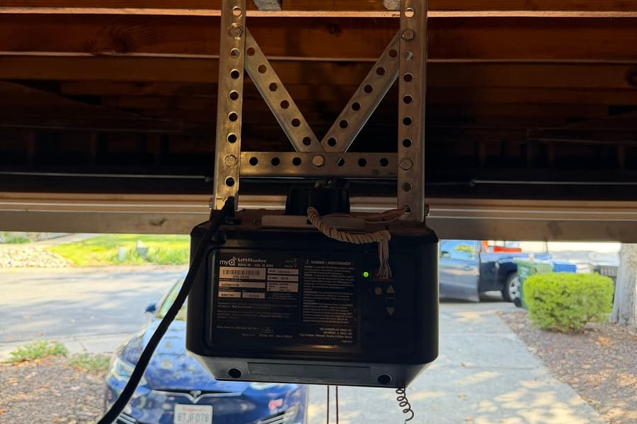 A LiftMaster myQ garage door opener securely remounted on galvanized steel angle-iron bracing under garage ceiling joists